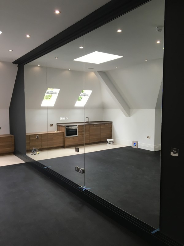 Frameless glass partition in loft conversion by Cricklewood glaziers