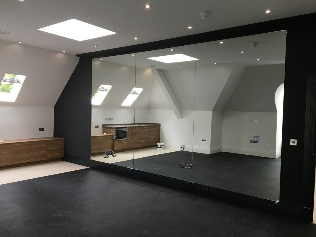 Frameless glass wall dividing loft conversion in Cricklewood